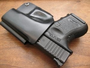 Black plastic weapon holster with gun inside