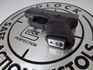 Glock 26 against large silver Glock company logo